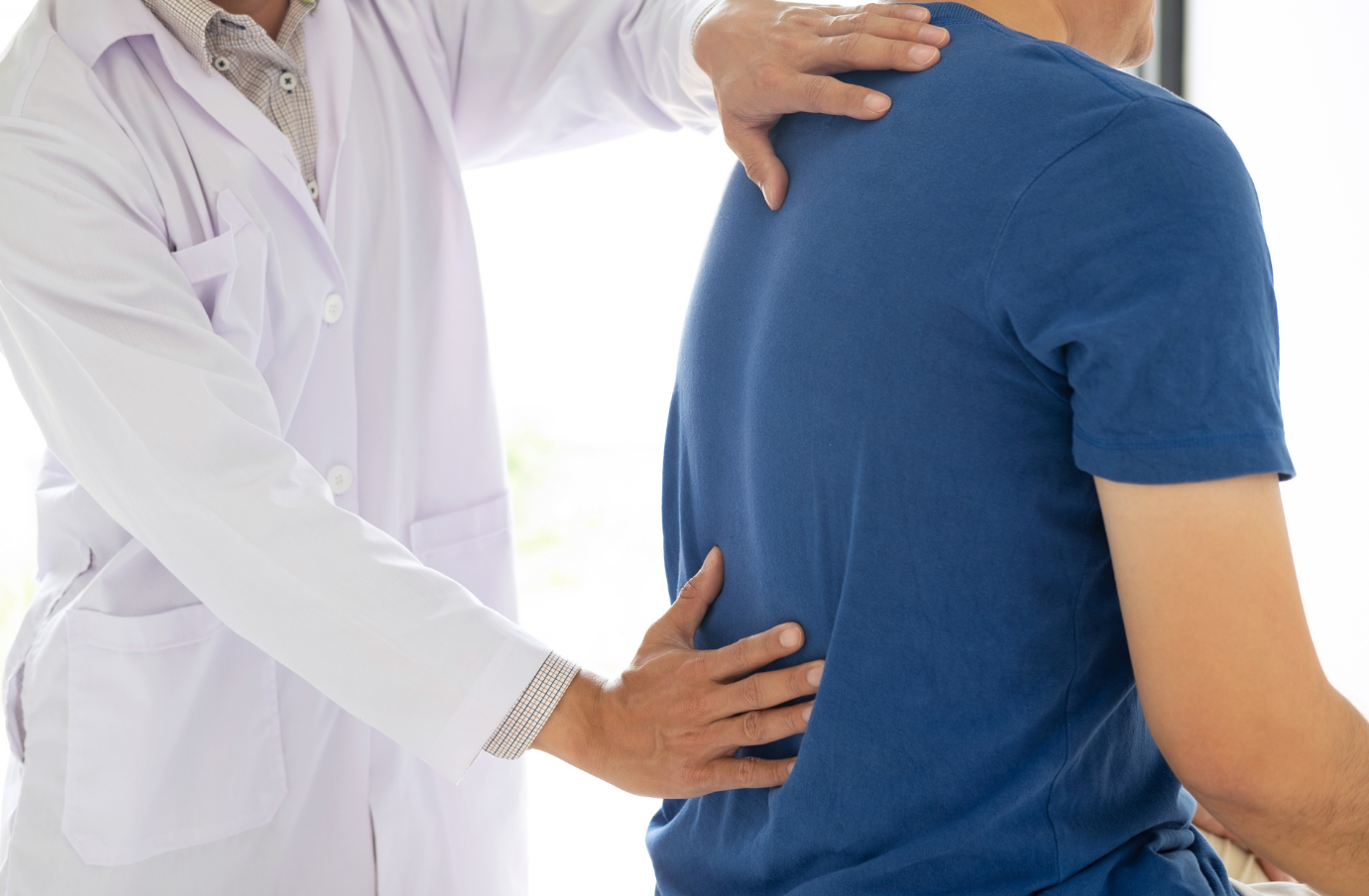 A doctor assisting a patient with upper back stiffness and mobility improvement.