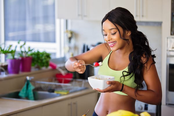 Fit woman in her 30s enjoying a high-protein breakfast, promoting a balanced, healthy lifestyle.