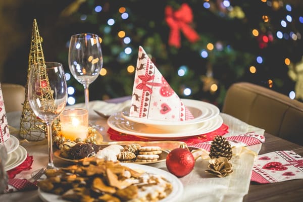 Festive Christmas table with holiday treats, decorations, and warm candlelight